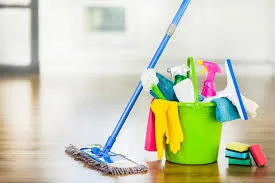 A mop, bucket and cleaning supplies ready on a wooden floor